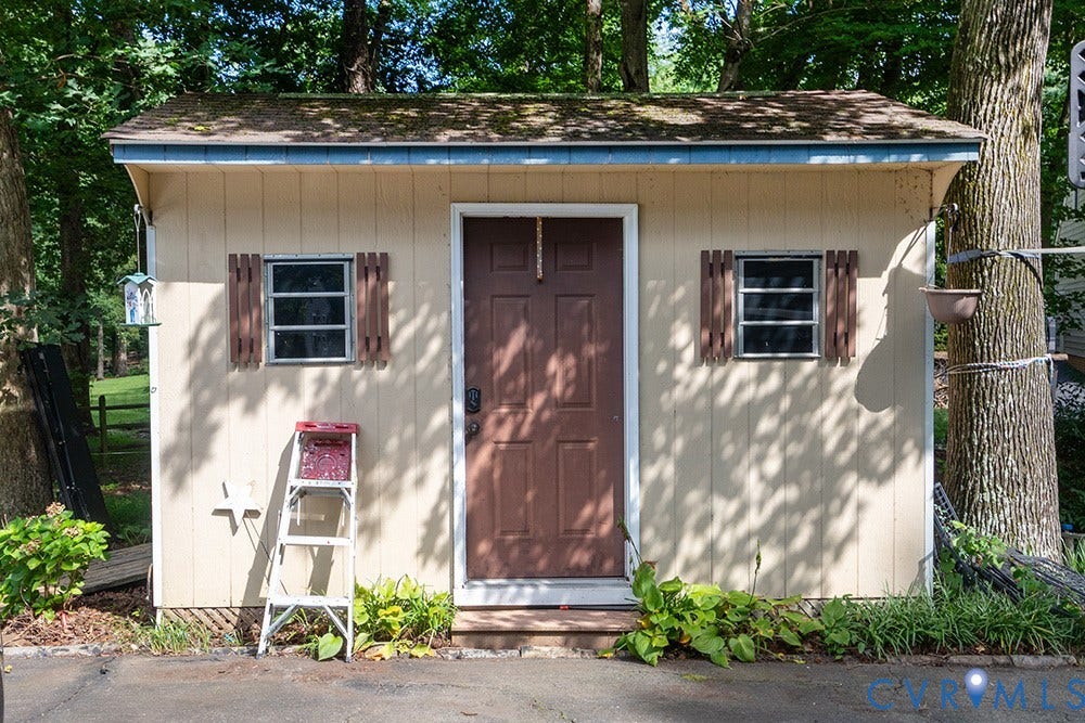 419 Rossmere Drive, Walton Park, Midlothian, VA 23114 Utility shed with horizontal siding, a brown panel door, and two windows with decorative shutters