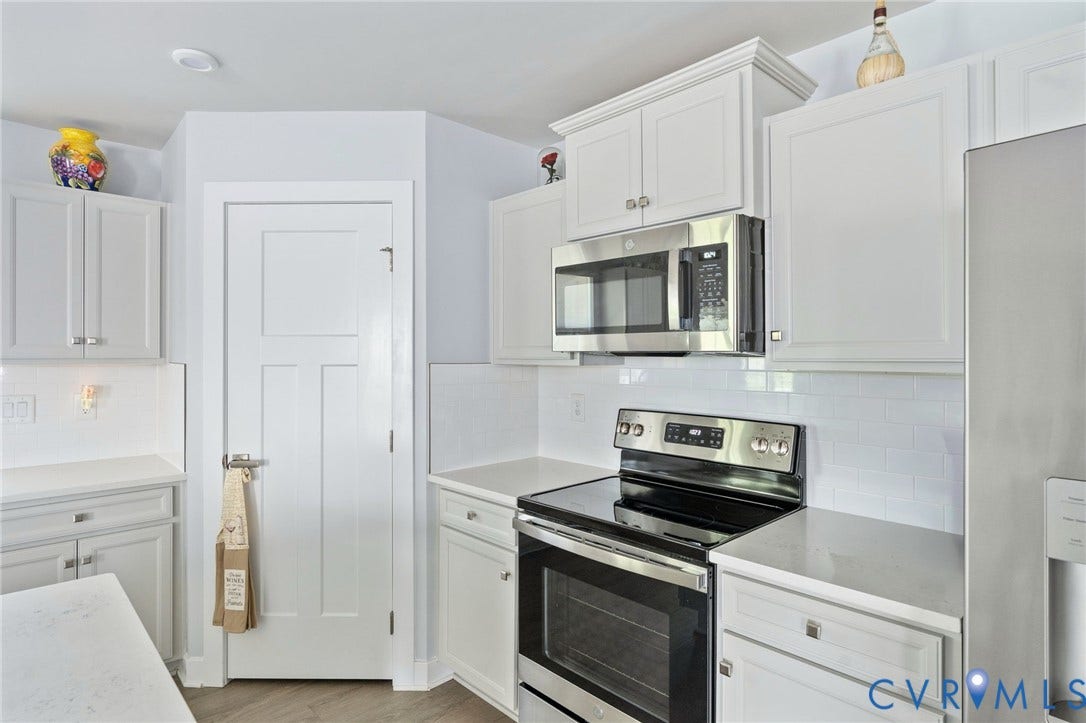 7484 Southamptonshire Way, Autumn Pines, New Kent, VA 23124 Modern kitchen with white shaker cabinetry, quartz countertops, white subway tile backsplash, stainless steel appliances, and wood-finish flooring