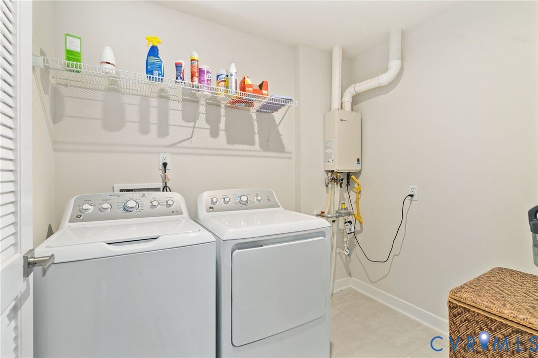 7484 Southamptonshire Way, Autumn Pines, New Kent, VA 23124 Dedicated laundry area featuring a white top-load washing machine and front-load dryer, wall-mounted wire shelving, and a tankless water heater