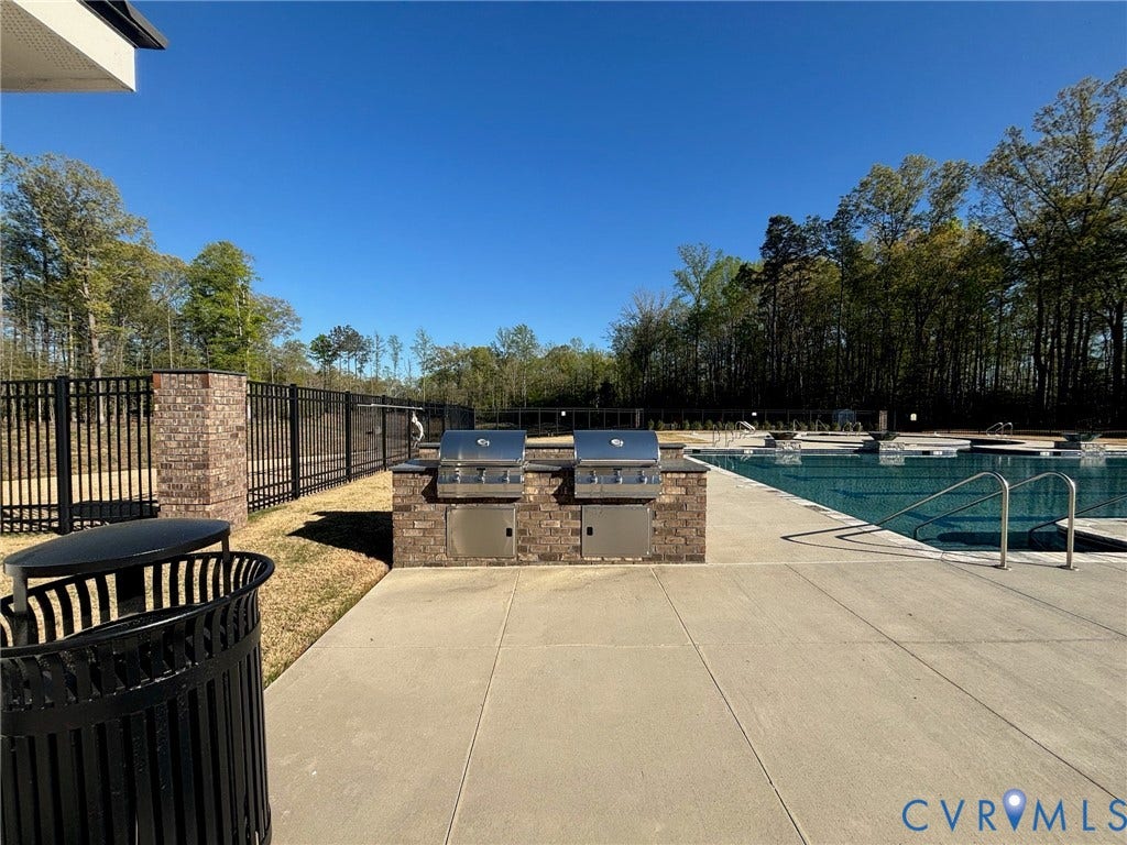 7484 Southamptonshire Way, Autumn Pines, New Kent, VA 23124 Outdoor grilling station featuring two built-in stainless steel grills, brick surround, and a concrete patio