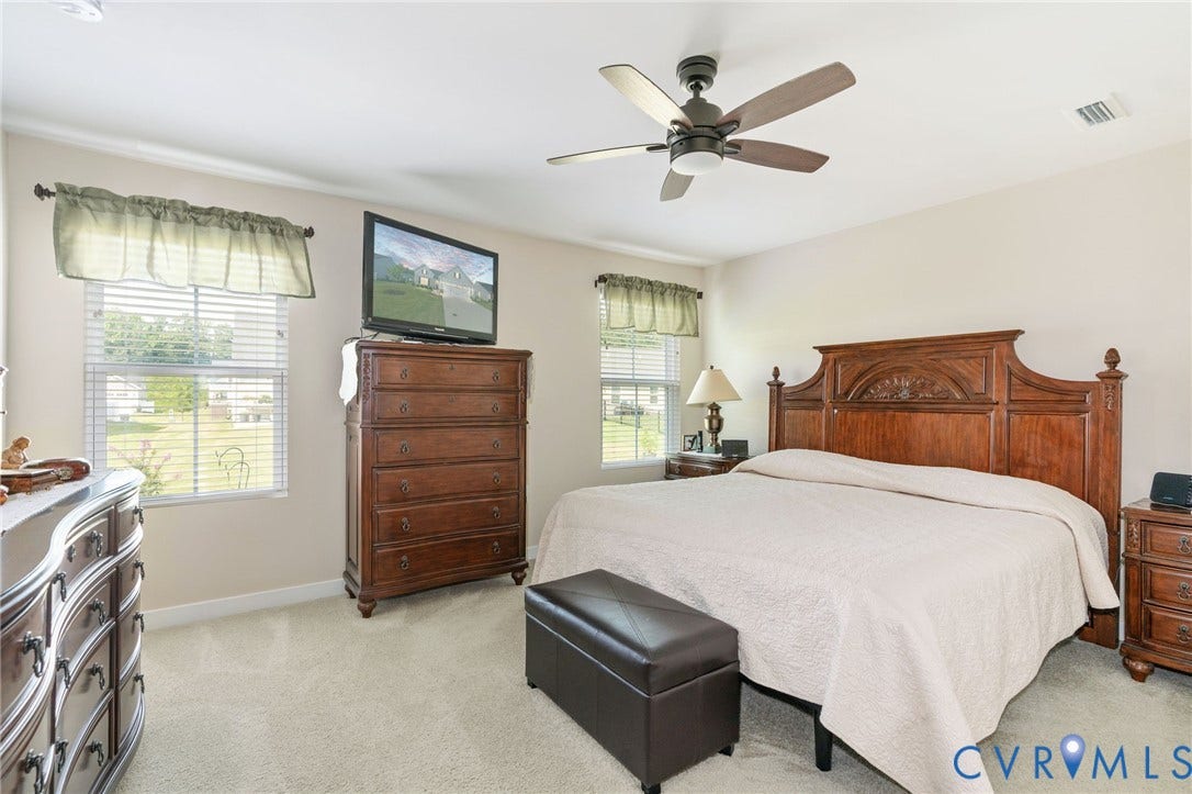 7484 Southamptonshire Way, Autumn Pines, New Kent, VA 23124 Carpeted bedroom featuring two windows with blinds, a ceiling fan, and painted walls