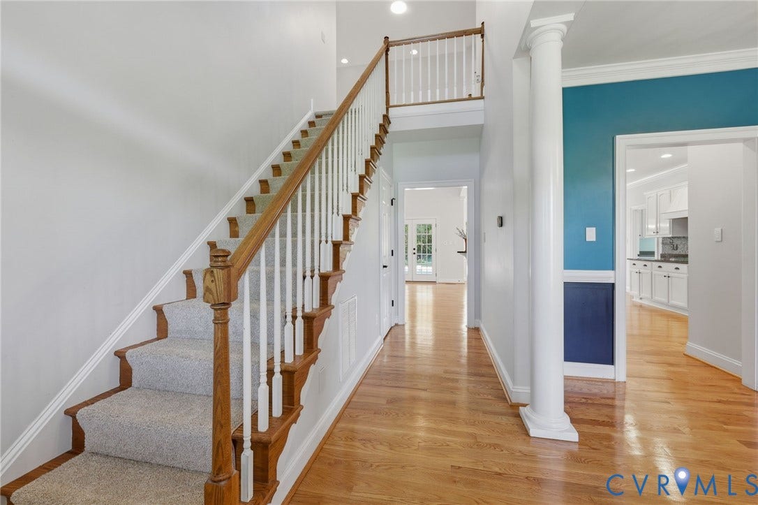16225 Parrish Farms Road, Montpelier, VA 23192 Foyer featuring hardwood flooring, a carpeted staircase with wood handrails and white balusters, a decorative column, and an upper-level landing