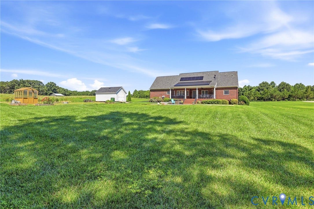 16225 Parrish Farms Road, Montpelier, VA 23192 Expansive green lawn surrounds a brick residence featuring a covered patio, solar panels, and a detached storage building