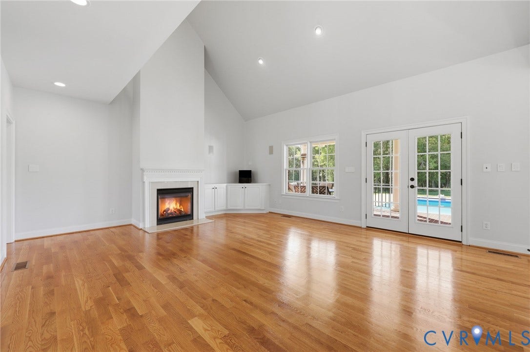 16225 Parrish Farms Road, Montpelier, VA 23192 Living area featuring wood-finish flooring, a fireplace with a white mantel, vaulted ceilings, built-in cabinetry, and French doors opening to an outdoor pool