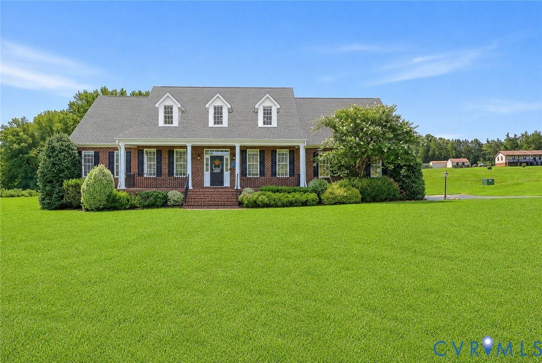 16225 Parrish Farms Road, Montpelier, VA 23192 Traditional brick home featuring a covered front porch with white columns, black shutters, and three dormer windows