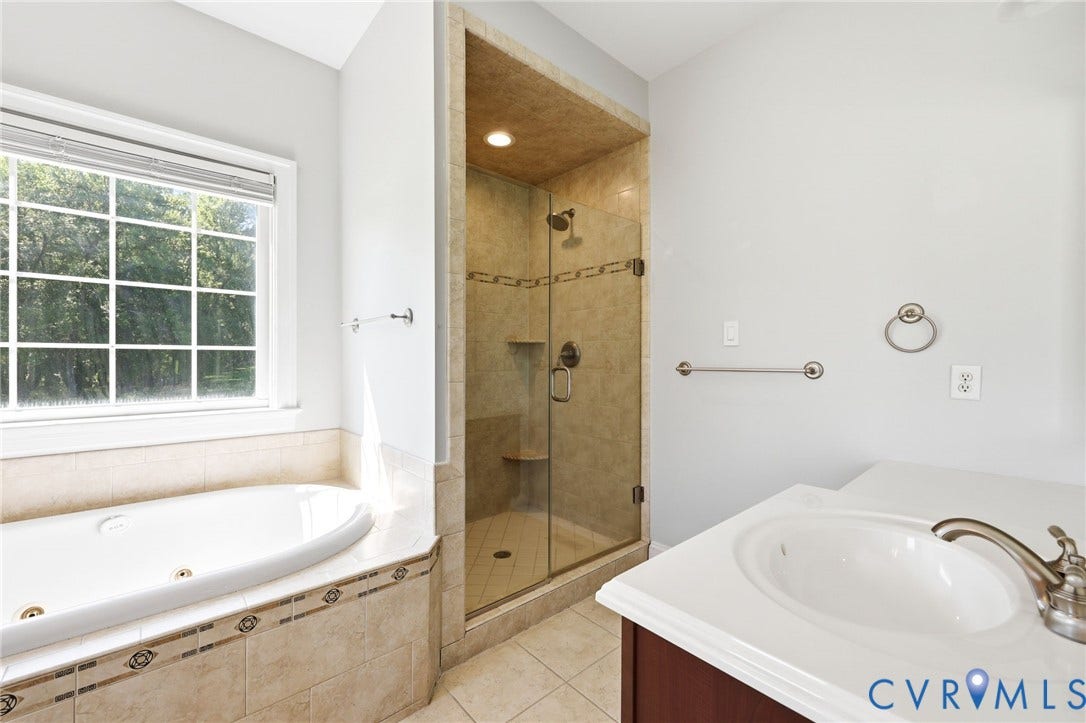 16225 Parrish Farms Road, Montpelier, VA 23192 Soaking tub with tiled surround, adjacent to a glass-enclosed shower with tiled walls and built-in bench