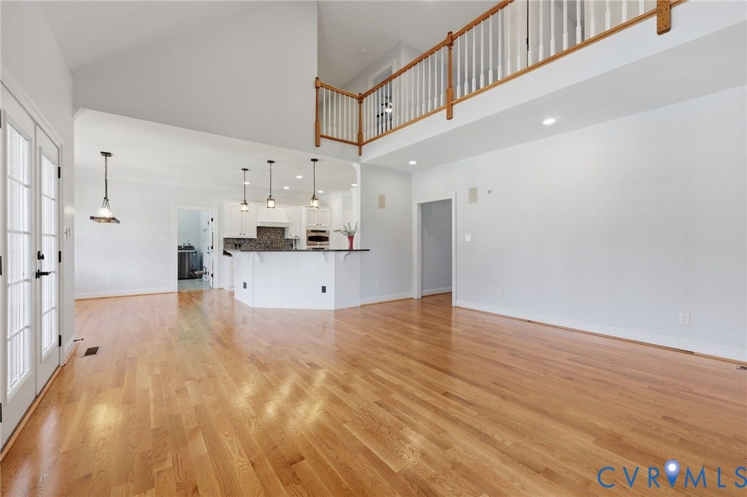 16225 Parrish Farms Road, Montpelier, VA 23192 Expansive open-concept living area featuring wood-finish flooring, vaulted ceilings, and a second-story overlook with a wood railing