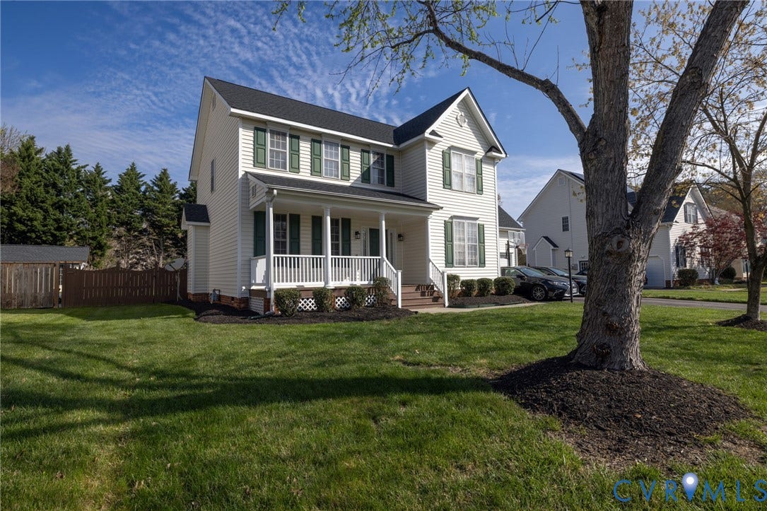 Two-story residence with white siding and dark green shutters