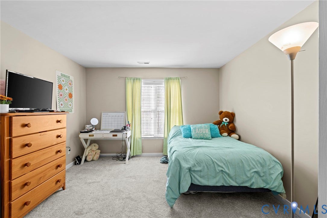Carpeted interior room featuring light neutral wall tones and a window with blinds