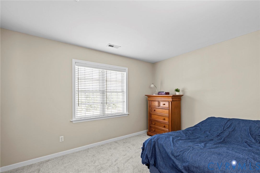 Neutral-toned walls complement the light grey carpeting