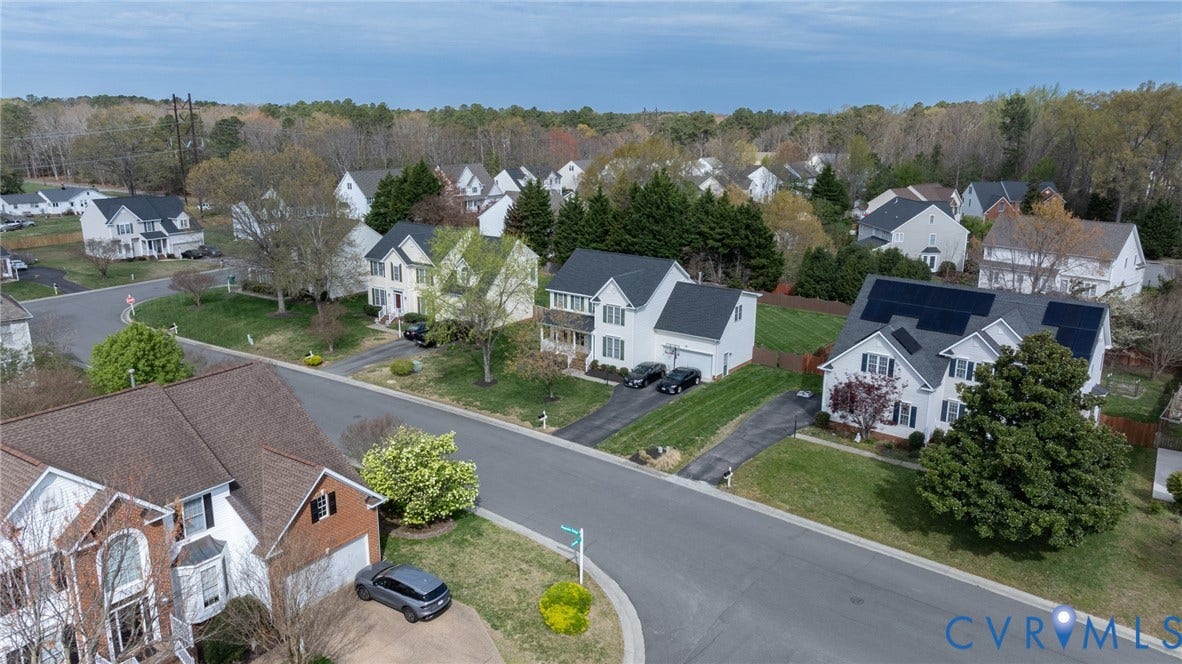 Residential street featuring single-family homes with pitched roofs and mature landscaping