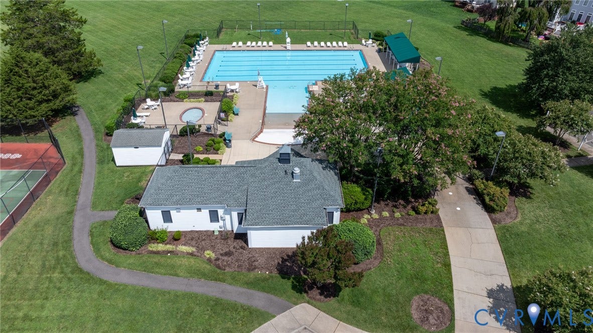 Community recreation area featuring a large swimming pool, an adjacent spa, a pool house, and tennis courts