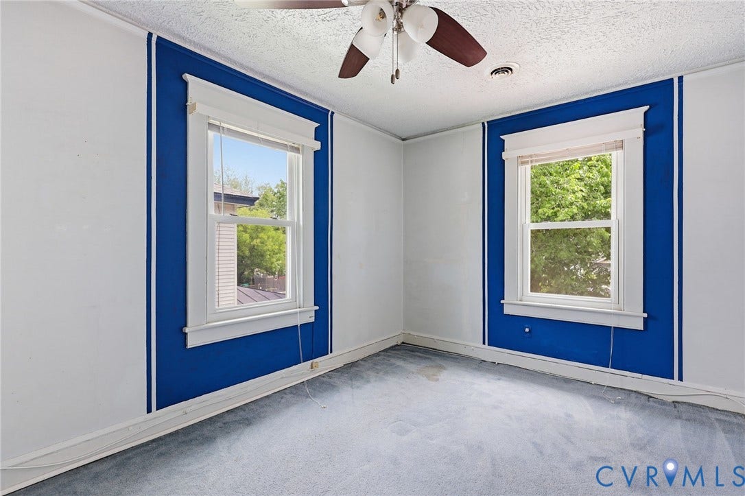 Room featuring two single-pane windows with white trim, a ceiling fan with integrated lighting, textured ceiling, and blue accent walls