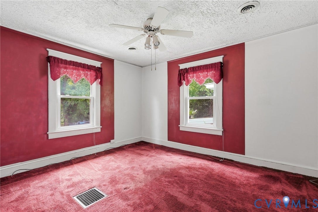 Room featuring two windows with white trim, red valances, and red wall accents