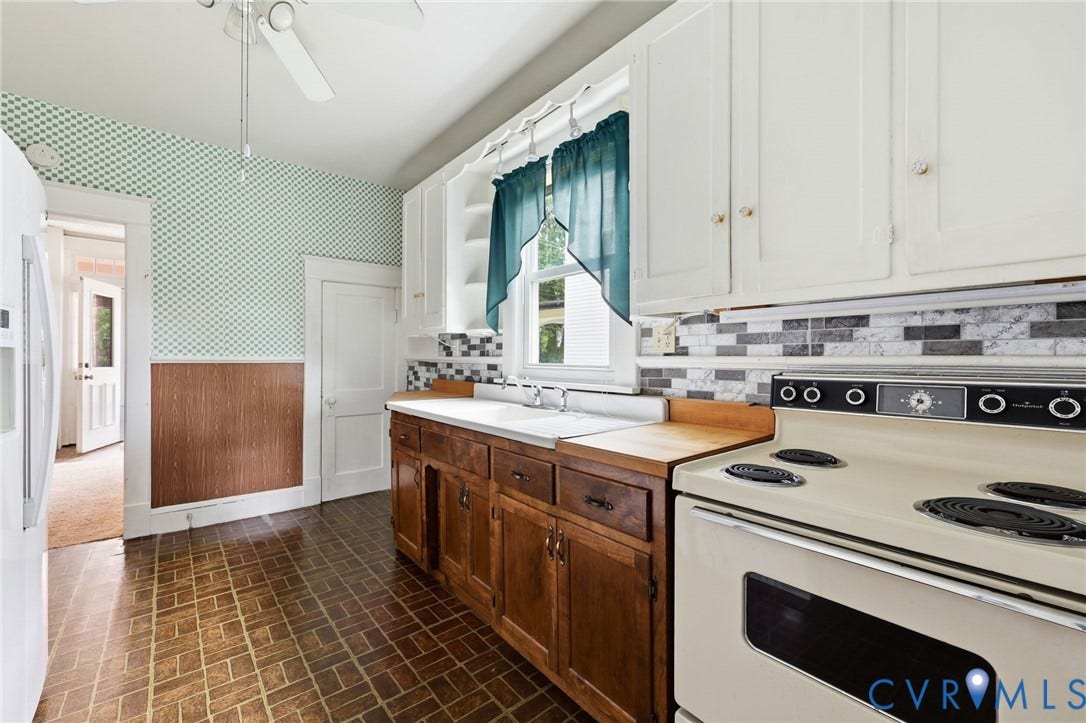 Kitchen featuring wood-finish flooring, white upper cabinetry, wood lower cabinetry, and a tile backsplash