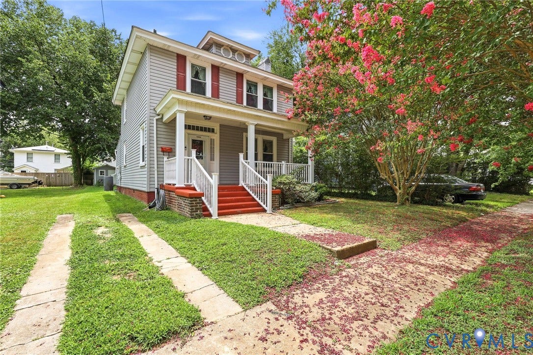 Two-story residence featuring light gray siding with red shutters and a white columned front porch