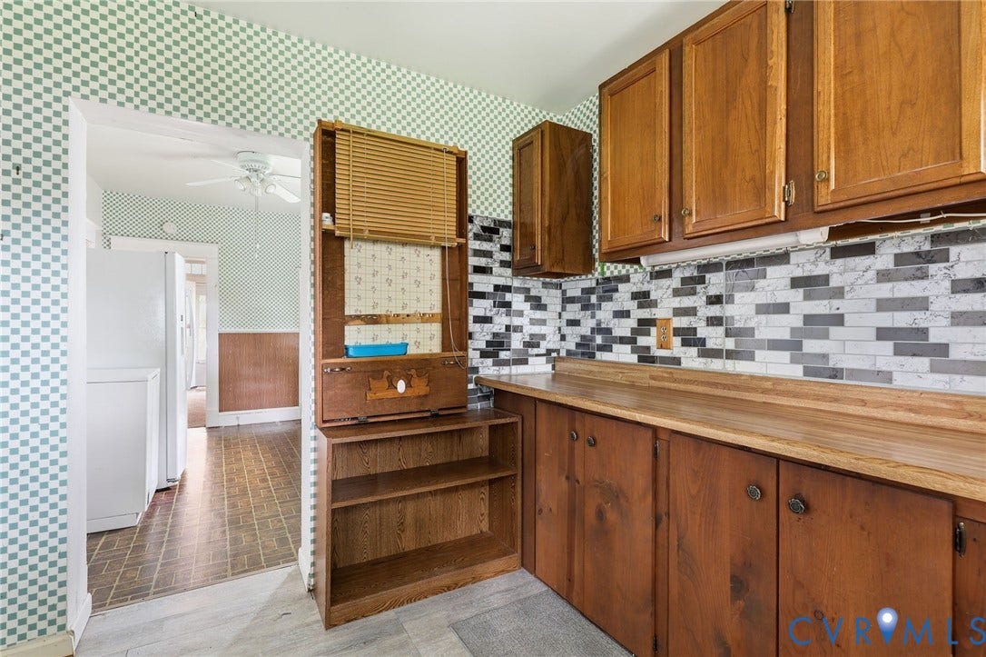 Kitchen featuring wood cabinetry, wood-finish countertops, and a mosaic tile backsplash