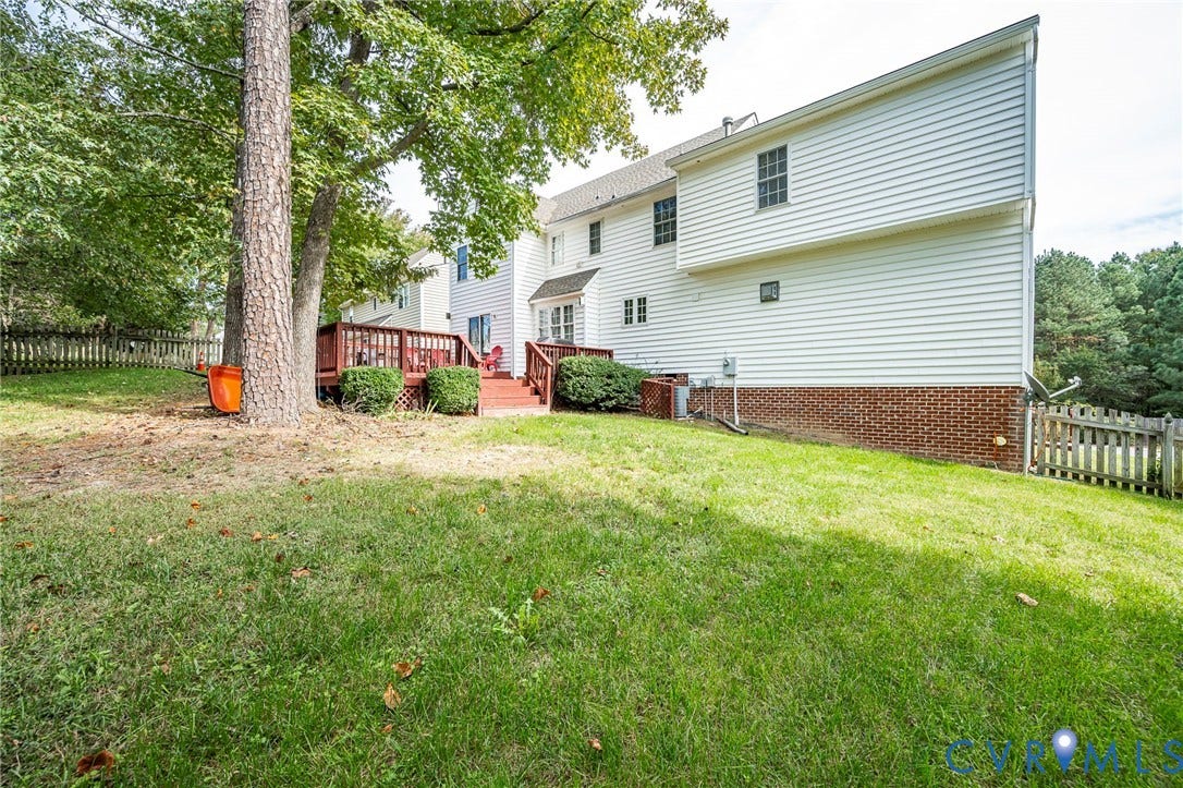 11821 Park Forest Way, Glen Allen, VA 23059 Expansive rear yard featuring a multi-level wood deck, white vinyl siding, brick foundation, and mature trees