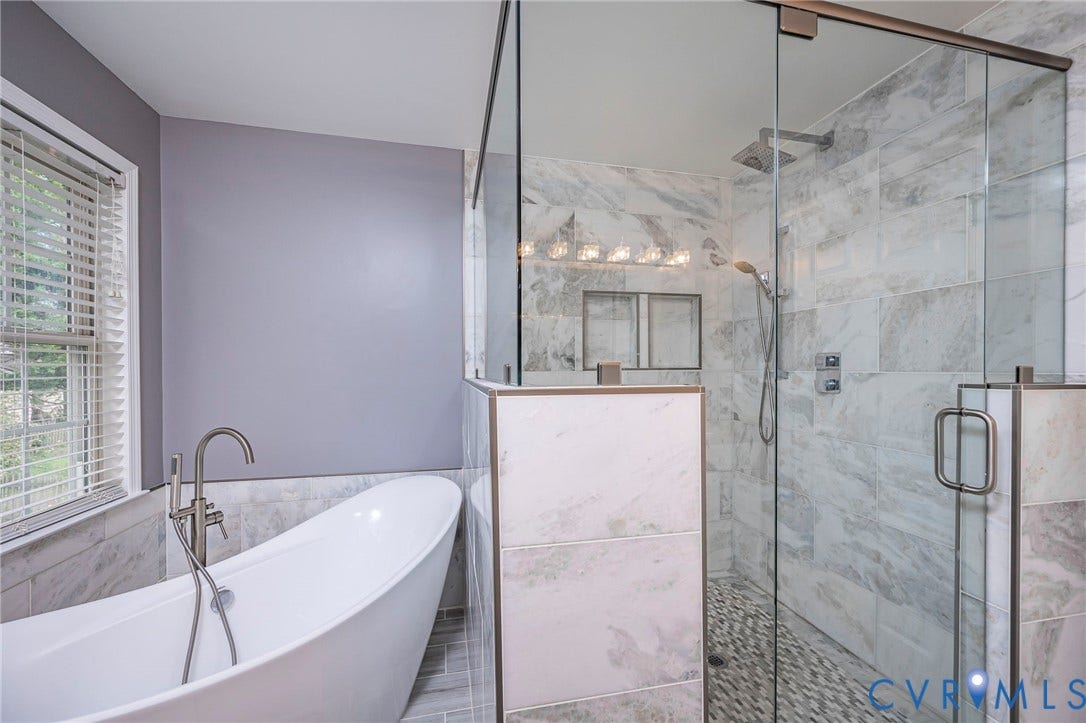 11821 Park Forest Way, Glen Allen, VA 23059 Modern bathroom featuring a freestanding soaking tub with a floor-mounted faucet, a glass-enclosed shower with tiled walls and a pebble floor, and recessed shower niches