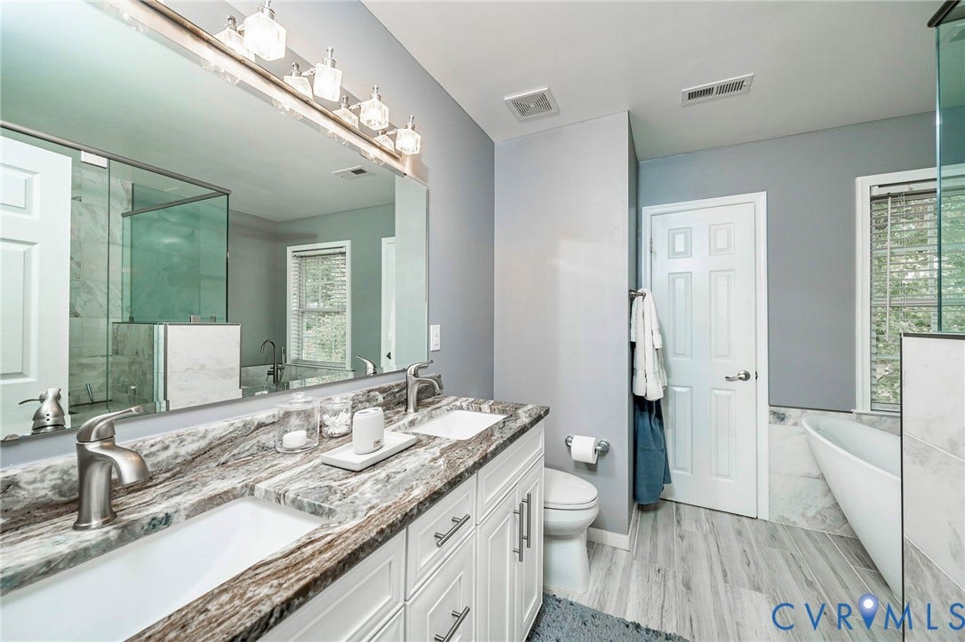 11821 Park Forest Way, Glen Allen, VA 23059 Bathroom featuring a dual vanity with a patterned countertop, undermount sinks, and brushed nickel fixtures