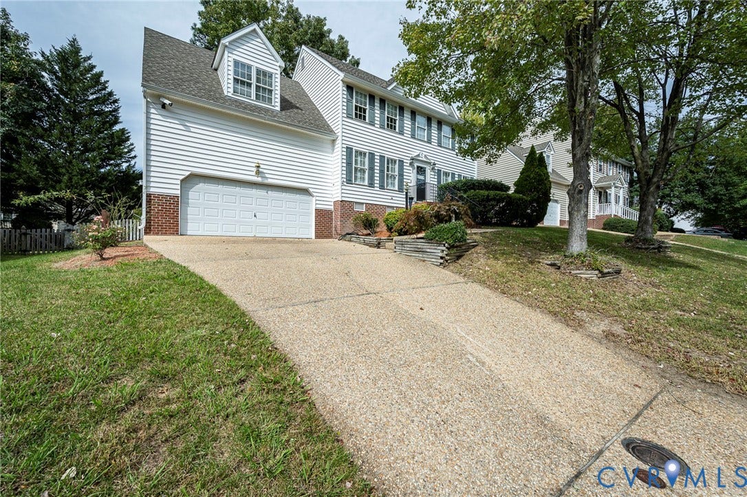 11821 Park Forest Way, Glen Allen, VA 23059 White siding residence featuring a two-car garage, dormer window, and brick foundation accents