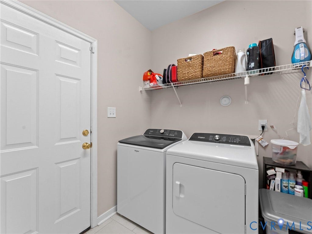 2606 Water Race Terrace, Watermill, Midlothian, VA 23112 Dedicated laundry area featuring a white paneled door with brass hardware, light neutral wall paint, and white tile flooring