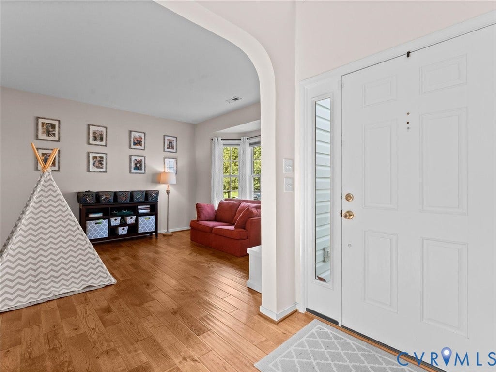 2606 Water Race Terrace, Watermill, Midlothian, VA 23112 Entryway featuring a white paneled door with sidelight, wood-finish flooring, and a wide arched opening into the adjacent room