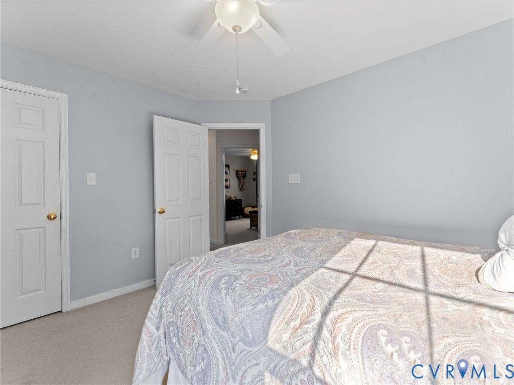 2606 Water Race Terrace, Watermill, Midlothian, VA 23112 Light gray painted walls define this space, featuring neutral carpet flooring, two paneled doors with brass hardware, and a ceiling fan with light fixture