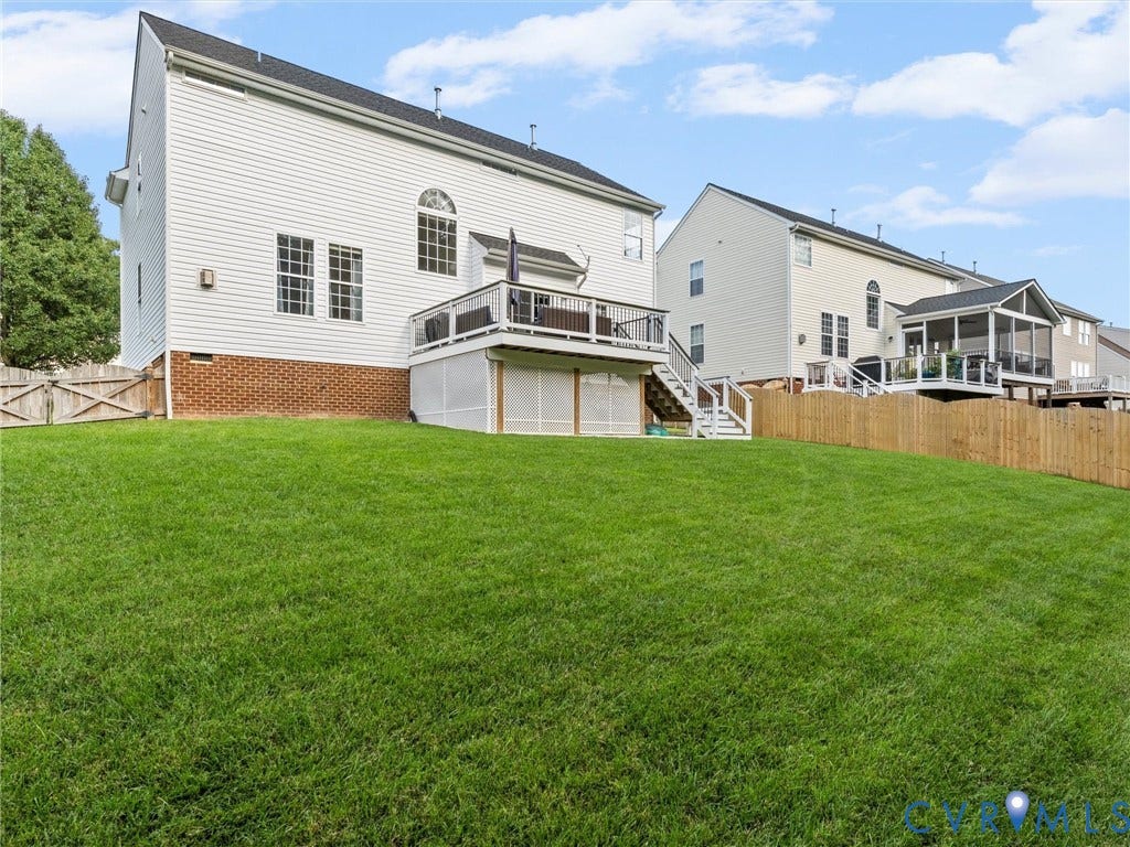 2606 Water Race Terrace, Watermill, Midlothian, VA 23112 Expansive backyard featuring a large green lawn, full privacy fencing, and a white wood deck with stairs