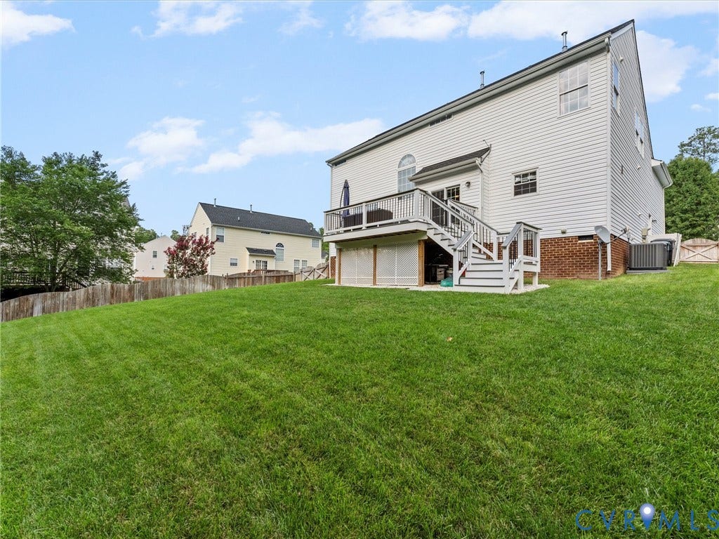 2606 Water Race Terrace, Watermill, Midlothian, VA 23112 Expansive green lawn with a two-story white siding exterior featuring a multi-level deck, lower patio area, and a privacy fence