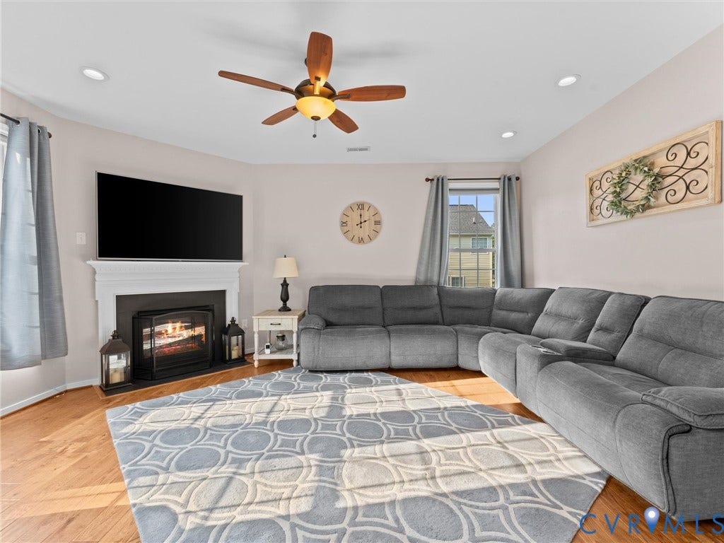 2606 Water Race Terrace, Watermill, Midlothian, VA 23112 Living area featuring a fireplace with a white mantel, recessed lighting, wood-finish flooring, a ceiling fan, and large windows
