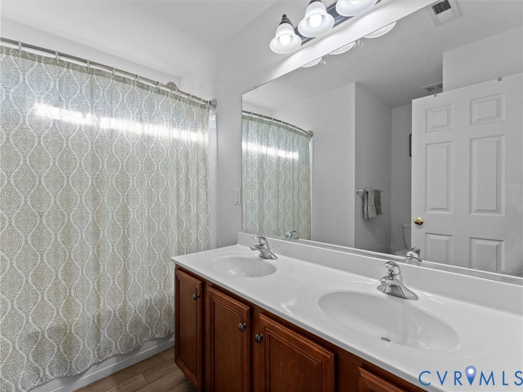 2606 Water Race Terrace, Watermill, Midlothian, VA 23112 Bathroom featuring a double vanity with integrated sinks, wood-finish cabinetry, and chrome fixtures