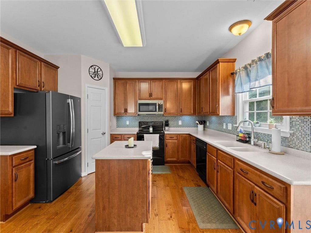 2606 Water Race Terrace, Watermill, Midlothian, VA 23112 Kitchen featuring wood-finish flooring, a central island, light-toned countertops, and a patterned tile backsplash