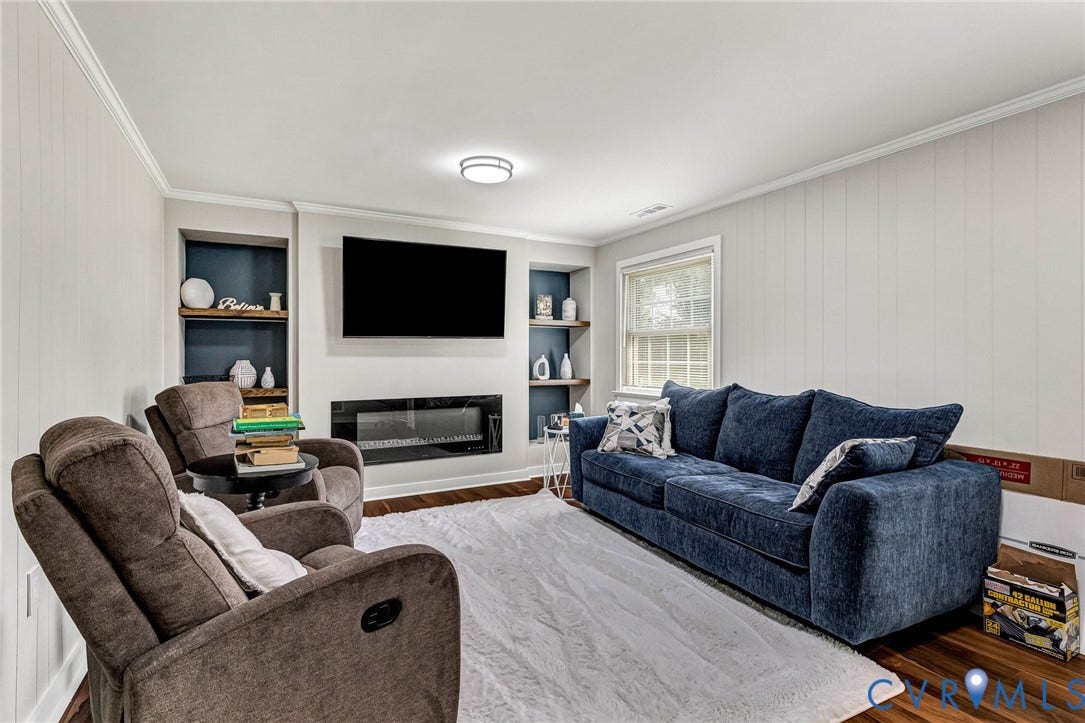 8318 Lydell Drive, Henrico, VA 23228 Built-in shelving, wall-mounted television, integrated fireplace, recessed lighting, and wood-finish flooring
