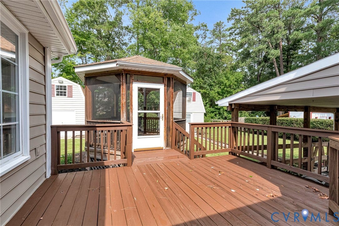 8318 Lydell Drive, Henrico, VA 23228 Expansive wood-finish deck with a screened-in gazebo, a covered outdoor area, and wood railings