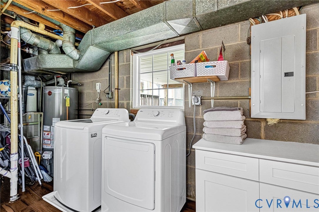 8318 Lydell Drive, Henrico, VA 23228 Laundry area featuring a window, wood-finish flooring, a white base cabinet with a countertop, and a water heater