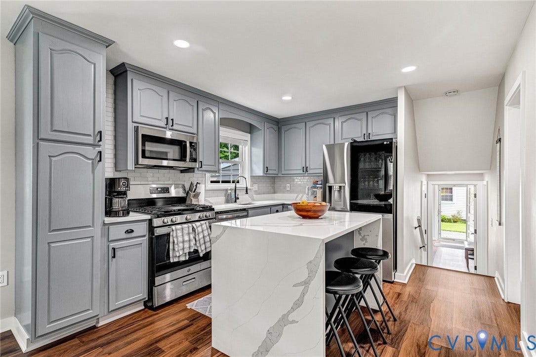 8318 Lydell Drive, Henrico, VA 23228 Modern kitchen featuring gray cabinetry, stainless steel appliances, a white waterfall island, and wood-finish flooring