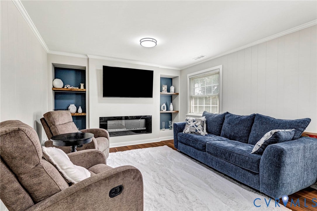 8318 Lydell Drive, Henrico, VA 23228 Built-in shelving, integrated electric fireplace, wood-finish flooring, crown molding, and recessed lighting