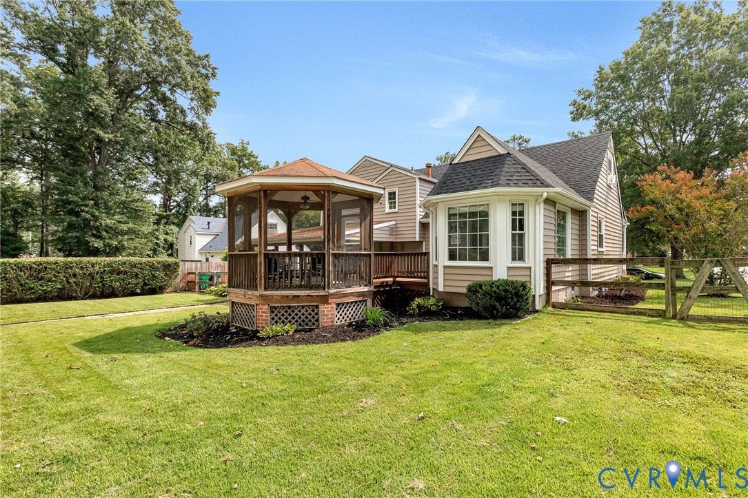 8318 Lydell Drive, Henrico, VA 23228 Landscaped yard featuring a screened gazebo with wood decking, a bay window with a shingled roof, and a wood fence