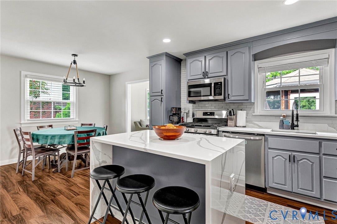 8318 Lydell Drive, Henrico, VA 23228 Kitchen featuring a waterfall island with white countertops, gray cabinetry, stainless steel appliances, and wood-finish flooring