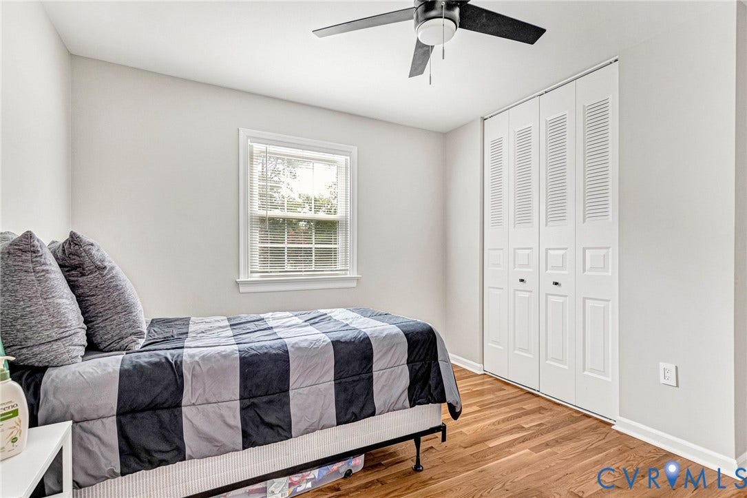 8318 Lydell Drive, Henrico, VA 23228 Wood-finish flooring, white louvered bifold closet doors, a single window, and a ceiling fan
