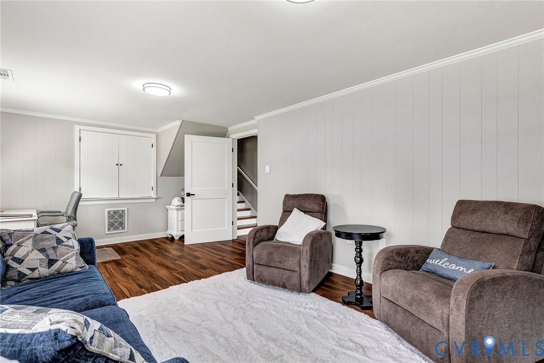 8318 Lydell Drive, Henrico, VA 23228 Wood-finish flooring with white baseboards, recessed lighting, and a white paneled door with black hardware