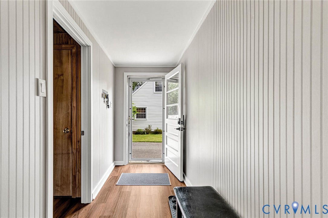 8318 Lydell Drive, Henrico, VA 23228 Hallway featuring wood-finish flooring, vertical paneling, and an exterior door with glass panels