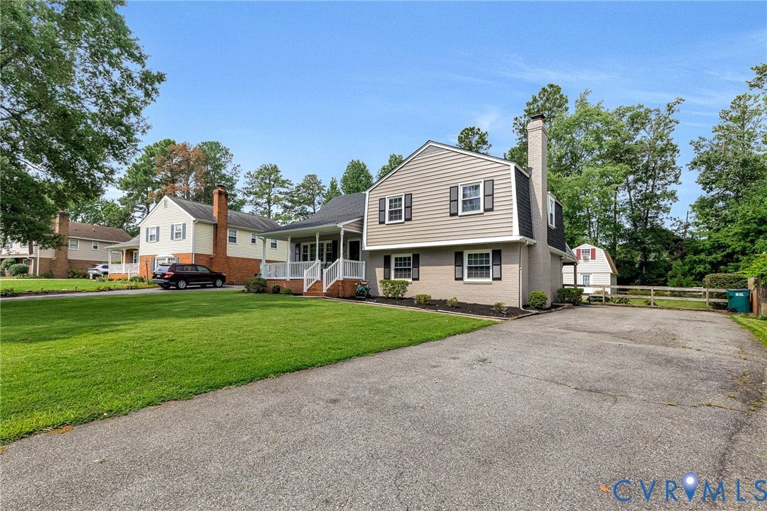 8318 Lydell Drive, Henrico, VA 23228 Two-story exterior with siding and brick, featuring a covered porch with white railings, a front lawn, and a paved driveway