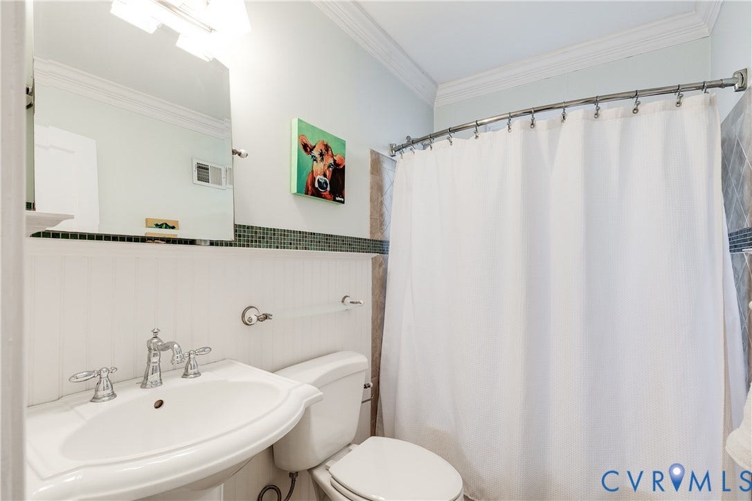 5204 Caledonia Road, Westover Hills, Richmond, VA 23225 Pedestal sink with chrome faucet, wainscoting, decorative tile accent band, curved shower rod, and crown molding