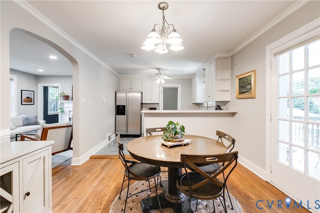 5204 Caledonia Road, Westover Hills, Richmond, VA 23225 Hardwood flooring extending through the dining area, kitchen with white cabinetry and stainless steel refrigerator, and French doors providing exterior access
