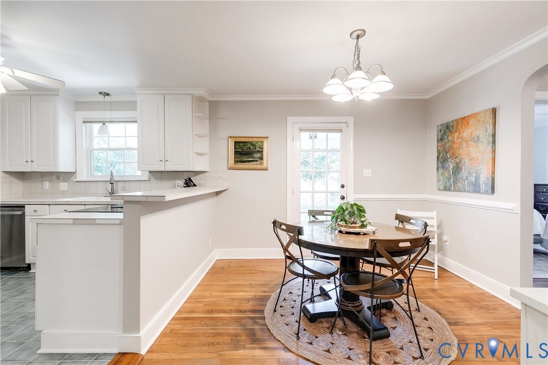 5204 Caledonia Road, Westover Hills, Richmond, VA 23225 Hardwood flooring, crown molding, chair rail molding, white kitchen cabinetry, and a full-light door