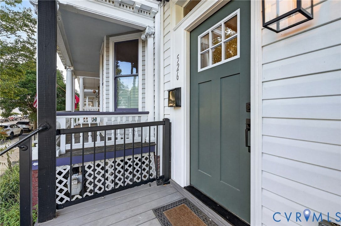 526 N 33rd Street, Church Hill, Richmond, VA 23223 Welcoming front entry featuring a dark green six-panel door, black metal railing with geometric lattice detailing, composite decking, and a covered portico with white trim and ceiling