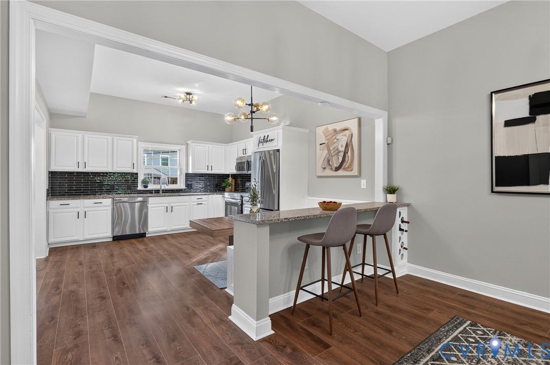 526 N 33rd Street, Church Hill, Richmond, VA 23223 Kitchen with LVP-finish flooring, white cabinetry, dark subway tile backsplash, stainless steel appliances, and a breakfast bar with stone countertop