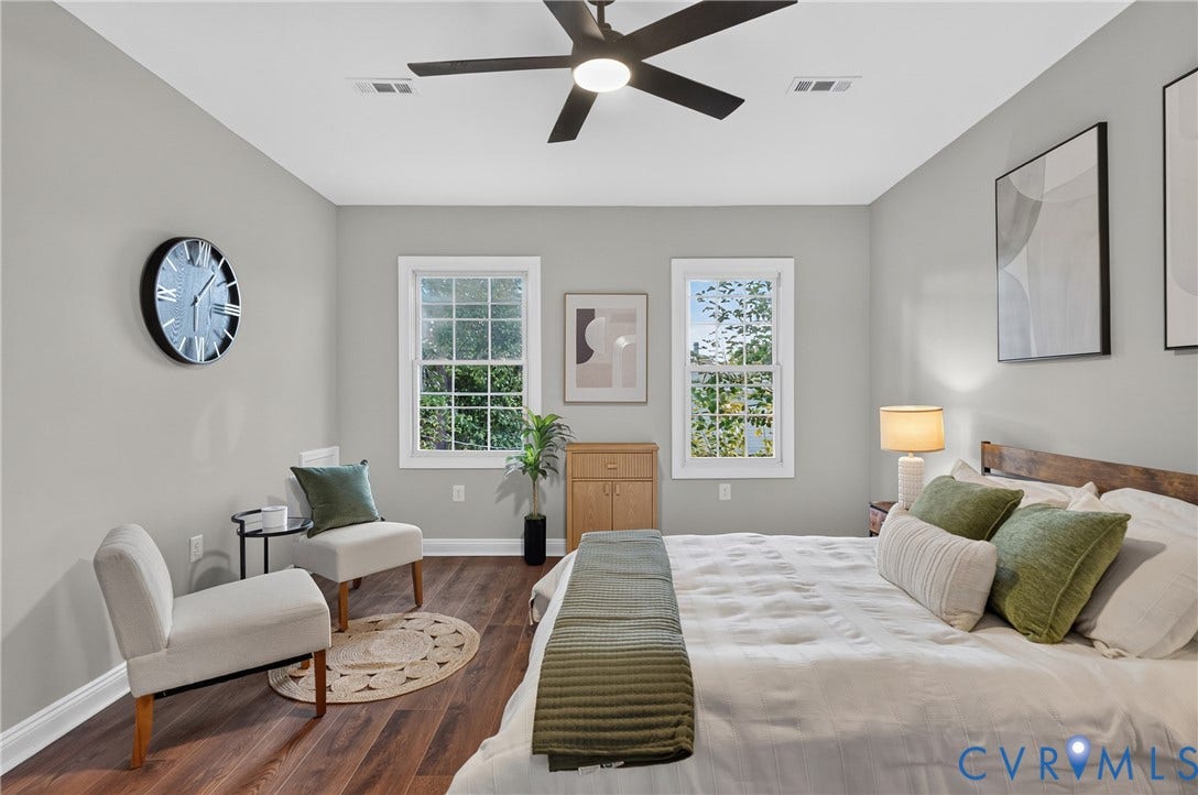 526 N 33rd Street, Church Hill, Richmond, VA 23223 Spacious room featuring wood-finish flooring, two large windows, a ceiling fan with integrated lighting, and neutral wall tones